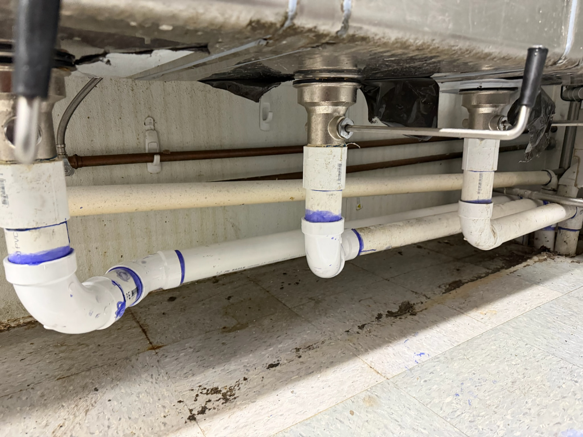 Rebuilt PVC drain lines and traps under a double kitchen sink